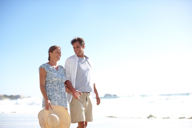 Il est juste l'homme dont elle a besoin dans sa vie Un heureux couple d'âge mûr marchant ensemble sur la plage