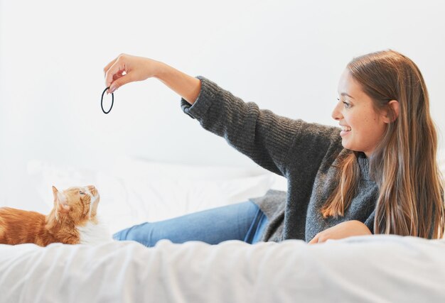 Il est sur le point de bondir dessus Photo d'une jeune femme jouant avec son chat à la maison