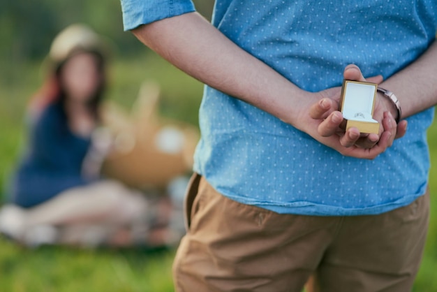 Il est sur le point de marquer son amour éternel pour elle Vue arrière d'un homme sur le point de proposer à sa petite amie une bague de fiançailles dans une boîte