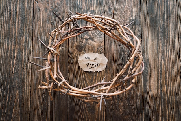 Photo il est ressuscité jésus couronne d'épines et de clous et croix sur un fond de bois jour de pâques