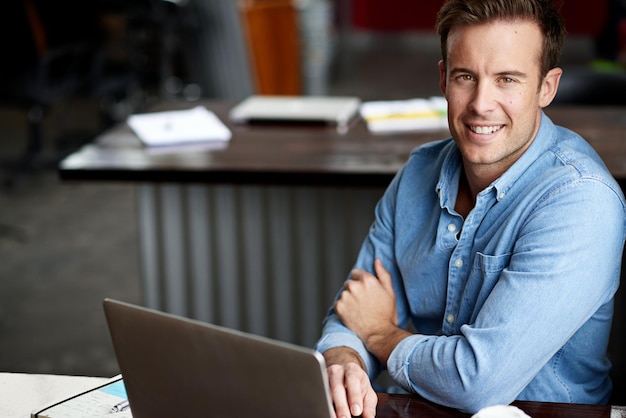 Il est temps d'être productif Photo d'un homme travaillant sur un ordinateur portable dans un bureau