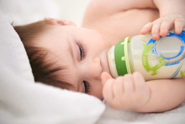 Il fait toujours la sieste après avoir été nourri Photo recadrée d'un adorable petit garçon faisant la sieste