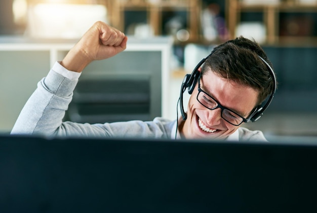 Il a maîtrisé la meilleure façon de vendre la marque de l'entreprise Photo d'un jeune agent de centre d'appels applaudissant tout en travaillant dans un bureau