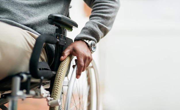 Il peut toujours se déplacer Photo recadrée d'un homme âgé méconnaissable assis dans son fauteuil roulant à la maison