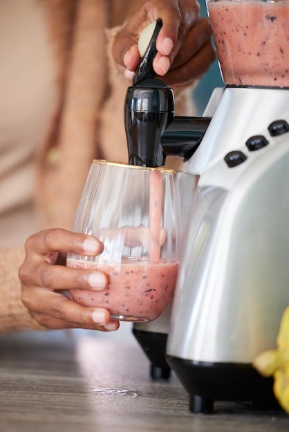 Il suffit de mélanger et de profiter Gros plan d'une femme méconnaissable versant un smoothie fraîchement mélangé dans un verre à la maison