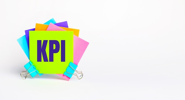 Il y a des autocollants multicolores brillants avec le texte KPI. Espace de copie