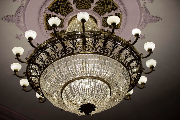 Il y a un beau lustre de théâtre au plafond et une lampe en verre chère