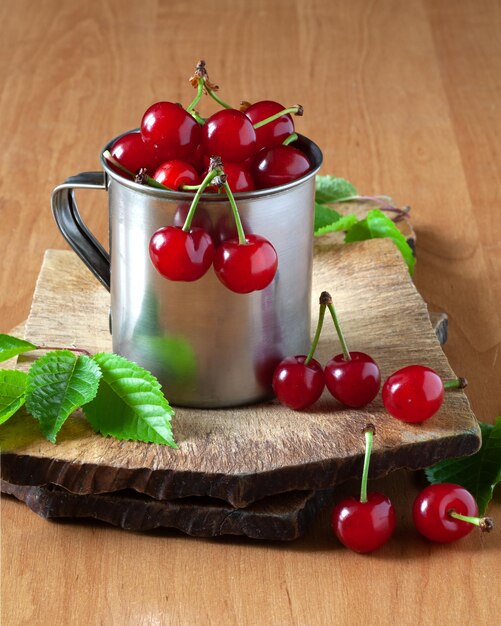 Il y a des cerises dans une tasse sur la table