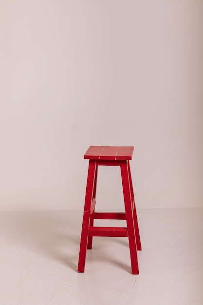 Il y a une grande chaise rouge dans une pièce lumineuse