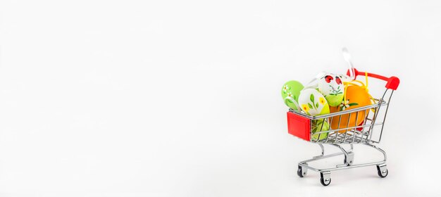 Il y a des oeufs de Pâques décorés dans le panier d'épicerie