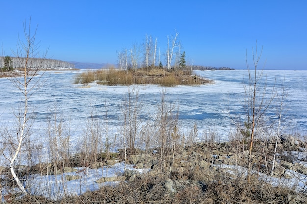 Une île sur un lac gelé par une claire journée ensoleillée