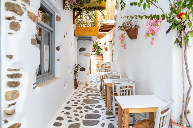 L'île de Naxos Cyclades Grèce Café traditionnel en plein air Table de chaise en bois sur des plantes pavées
