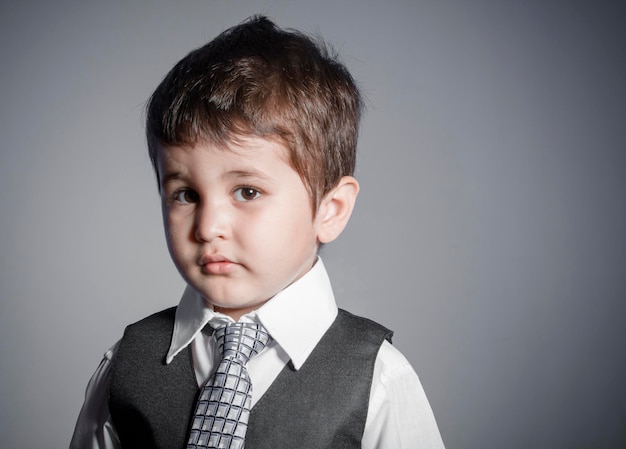 illusion, petit homme d'affaires, garçon aux cheveux bruns vêtu d'un costume et d'une cravate avec des visages et des expressions drôles