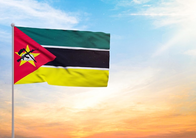 Illustration 3D d'un drapeau du Mozambique étendu sur un mât de drapeau et en arrière-plan un beau ciel avec un coucher de soleil