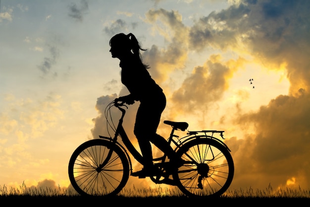 Illustration d&#39;une fille à vélo au coucher du soleil