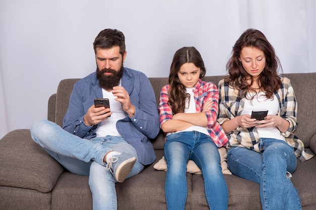 Ils doivent poser leurs téléphones. Parents sur smartphones ignorant l'enfant. Enfant malheureux