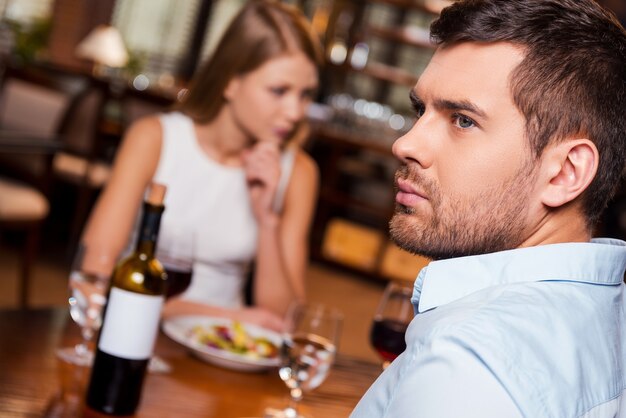 Ils n'ont plus rien à dire. Jeune homme frustré à l'écart alors qu'il était assis avec sa petite amie au restaurant