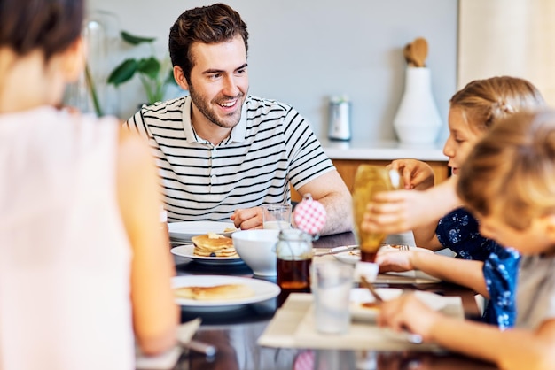 Ils profitent pleinement de leur repas ensemble Photo d'une famille prenant son petit déjeuner ensemble à la maison