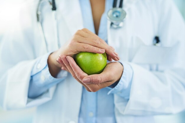 Ils sont remplis d'antioxydants puissants Gros plan d'un médecin non identifiable tenant une pomme