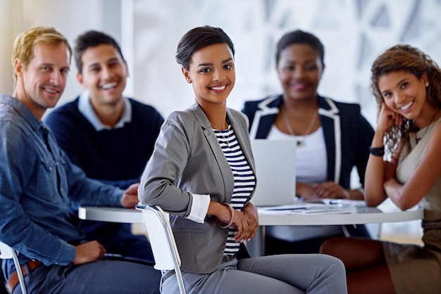 Ils travaillent mieux en équipe Portrait d'un groupe de collègues souriants assis dans un bureau