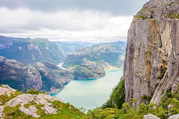 Image 4K de nuages spectaculaires et de touristes en randonnée à Preikestolen en Norvège