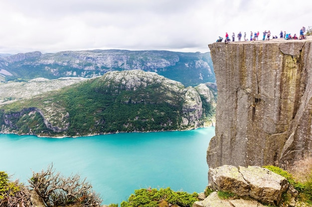 Photo image 4k de nuages spectaculaires et de touristes en randonnée à preikestolen en norvège