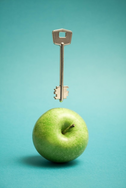 Image abstraite d'une pomme et d'une clé sur fond bleu