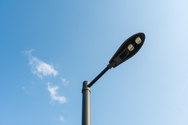 Image abstraite d'un réverbère moderne sur un lampadaire contre un ciel bleu Équipement d'éclairage pour le parking de la ville