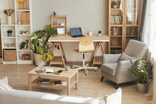 Image d'arrière-plan grand angle de l'intérieur confortable du bureau à domicile avec décor en bois, espace pour copie