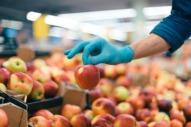 Image d'arrière-plan d'un homme en gants de protection cueillette des pommes