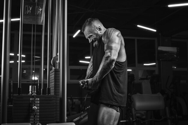 Image d'un athlète puissant soulevant des poids dans le gymnase. Pompage des épaules. Concept de remise en forme et de musculation. Technique mixte