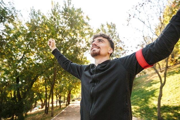 Image de beau jeune coureur d'homme de remise en forme sportive à l'extérieur dans le parc.