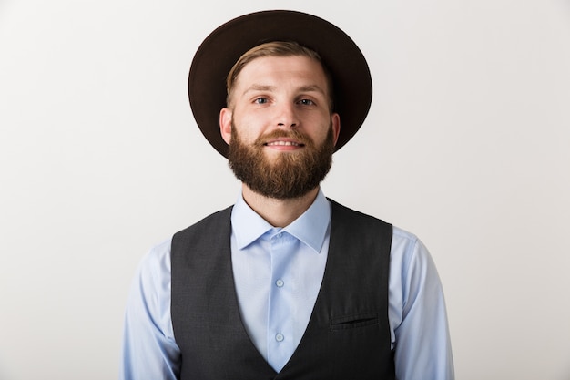 Image d'un beau jeune homme barbu debout isolé sur mur blanc posant.