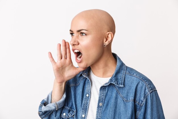 Image d'une belle femme chauve en colère qui crie posant isolée.