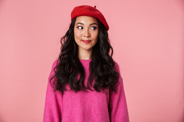 Image d'une belle fille asiatique positive aux longs cheveux noirs portant un béret souriant