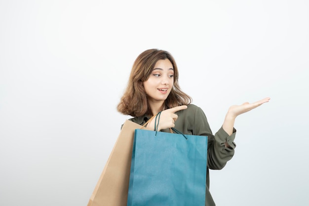 Image d'une belle fille aux cheveux courts avec des sacs à provisions debout. Photo de haute qualité