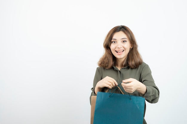 Image d'une belle fille aux cheveux courts avec des sacs à provisions debout. Photo de haute qualité