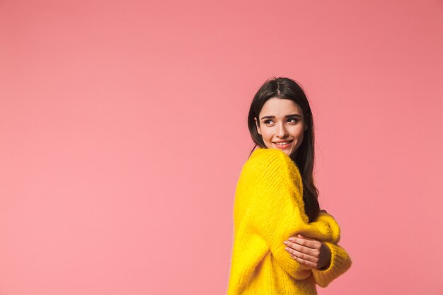 Image d'une belle jeune femme émotionnelle heureuse posant isolée sur rose.