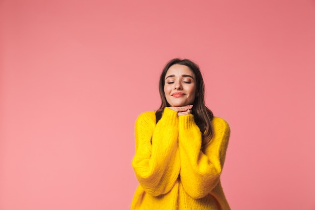 Image d'une belle jeune femme émotionnelle heureuse posant isolée sur rose.