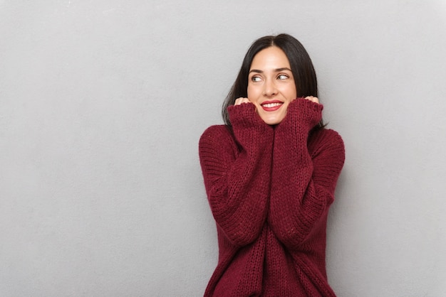 Image de la belle jeune femme habillée en pull bordeaux posant isolé.