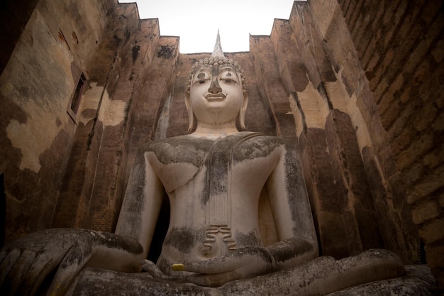 Image de Bouddha assis au temple Wat Si Chum dans le parc historique de Sukhothai, site du patrimoine mondial de l'UNESCO en Thaïlande