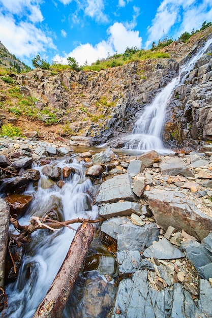 Image de chute d'eau vers le bas de la pente inclinée des roches grises dans les montagnes