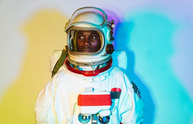 Image cinématographique d'un astronaute. Portrait coloré d'un homme avec une combinaison spatiale