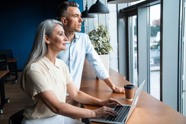 Image cinématographique d'une équipe commerciale multiethnique. Deux employés travaillant ensemble sur un projet au bureau