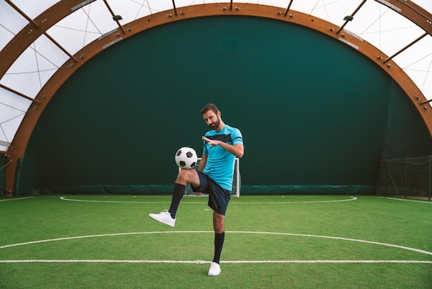 Image cinématographique d'un joueur de football freestyle faisant des tours avec le ballon