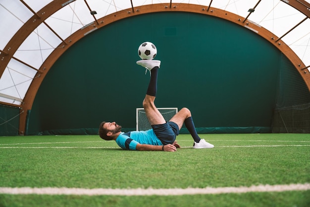 Image cinématographique d'un joueur de football freestyle faisant des tours avec le ballon