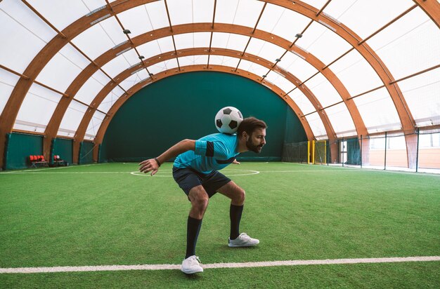 Image cinématographique d'un joueur de football freestyle faisant des tours avec le ballon