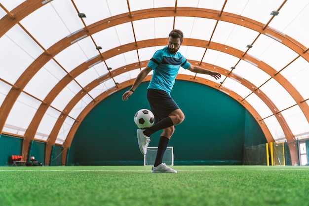 Image cinématographique d'un joueur de football freestyle faisant des tours avec le ballon