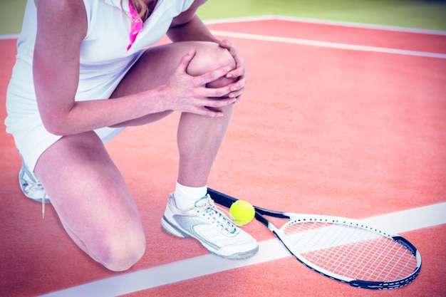 Image composée d'athlète blessé avec la raquette de tennis et la balle de tennis