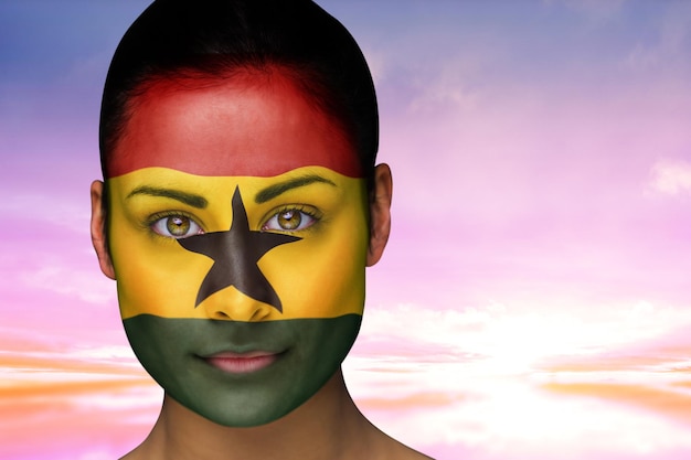 Image composée de belle brune au ghana facepaint contre le beau ciel bleu et jaune